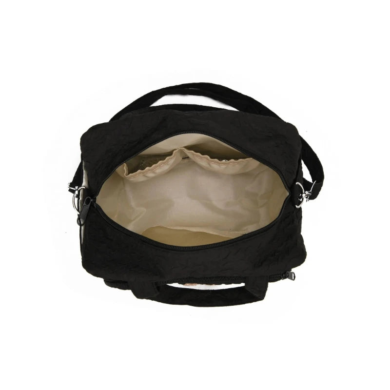 Compartiments intérieurs du sac à langer noir avec biberon et lingettes