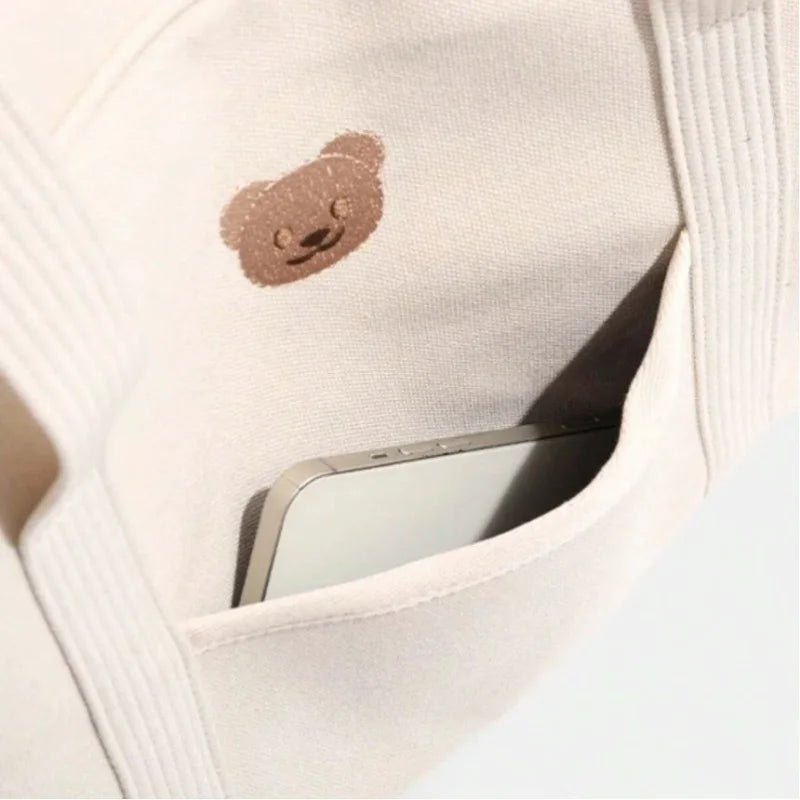 Détail de l'écusson ourson appliqué en façade du sac à langer beige