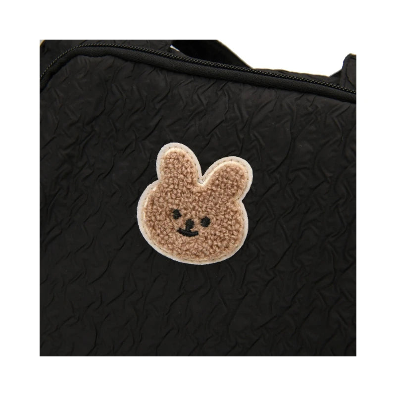 Gros plan sur l'écusson ourson appliqué du sac à langer noir