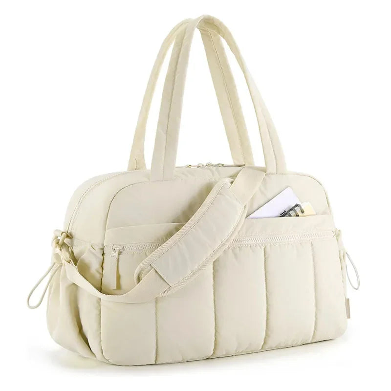 Sac à langer matelassé blanc cassé sur fond blanc, vue de face