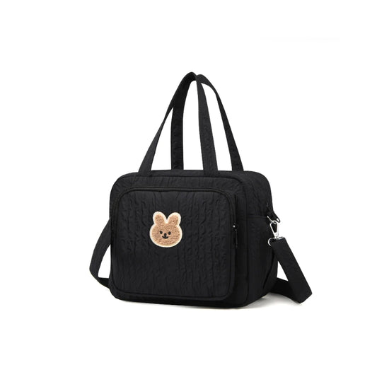 Sac à langer noir motif ourson posé sur fond blanc, vue de face